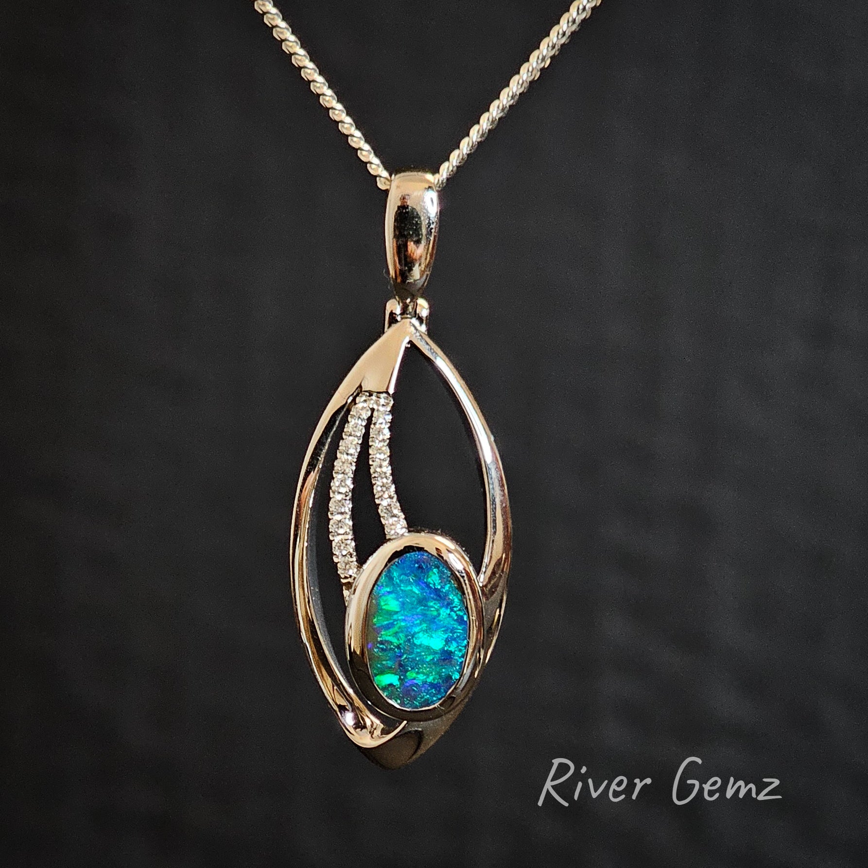 Blue and green boulder opal set in high grade white gold necklace with two lines of diamonds included.