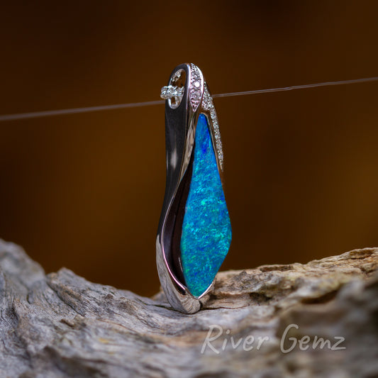 This side on view of the pendant shows the partial besel setting of the blue/green opal. The chain cleverly passes through a hidden eye rather than a separate bail.