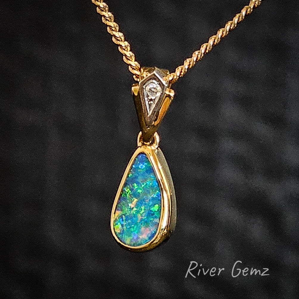 Slightly side on view of the multi-coloured dark opal besel set in a high-grade yellow gold necklace.