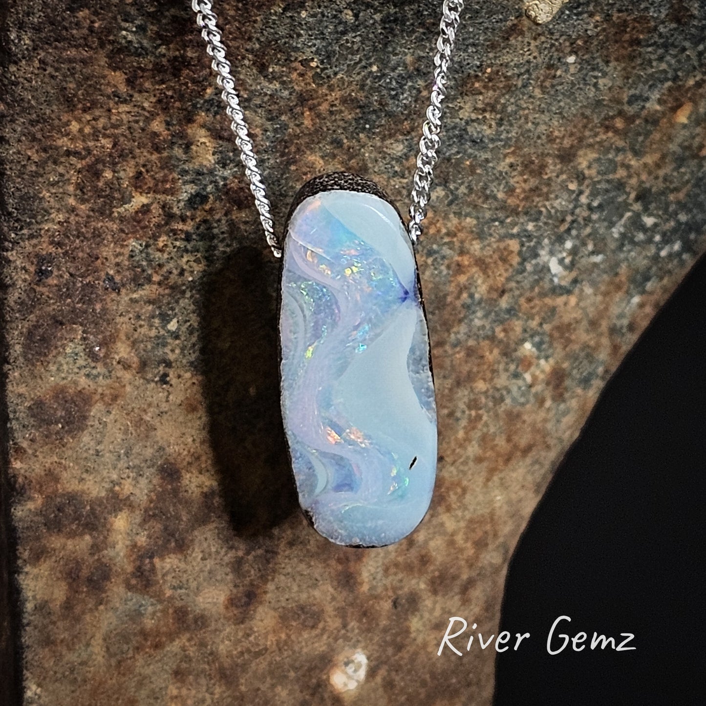 Multi-coloured boulder opal pendant with sterling silver chain.