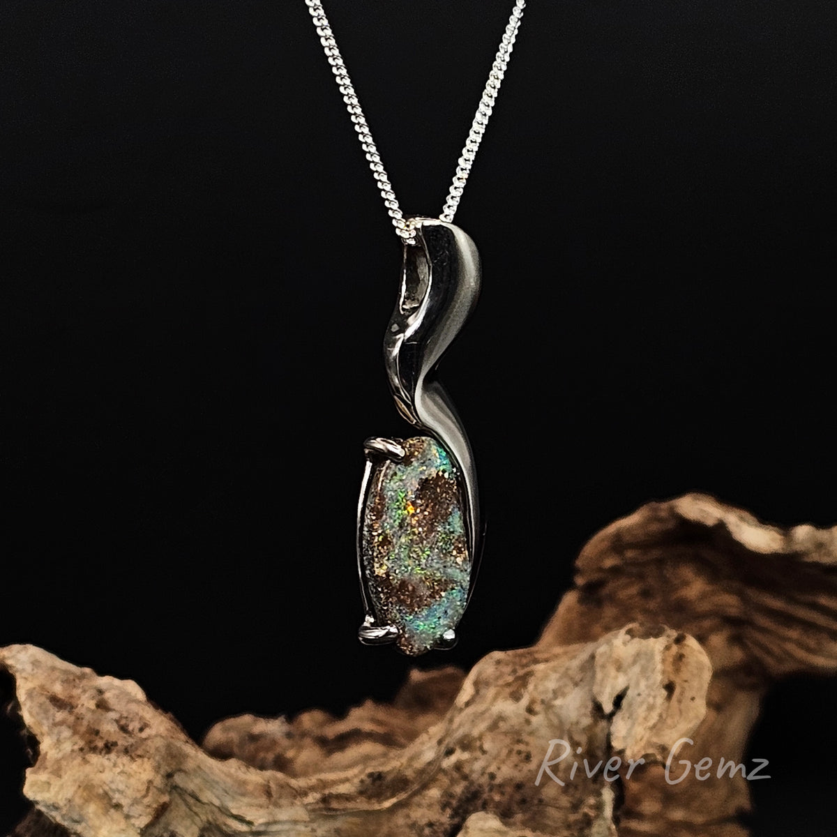Silver pendant with hidden bail and oval shaped boulder opal.