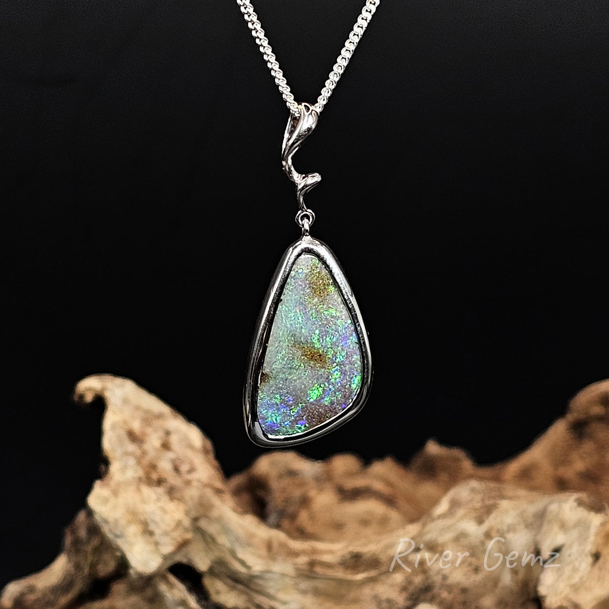 Triangular shaped green and blue boulder opal set in sterling silver pendant.