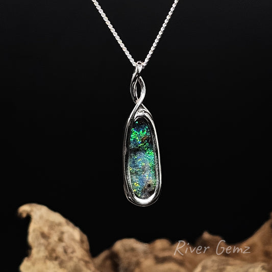 Oval shaped dark opal set in modern design necklace.