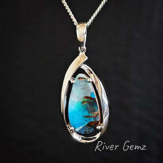 Tear drop shaped blue and green boulder opal claw set in silver necklace.