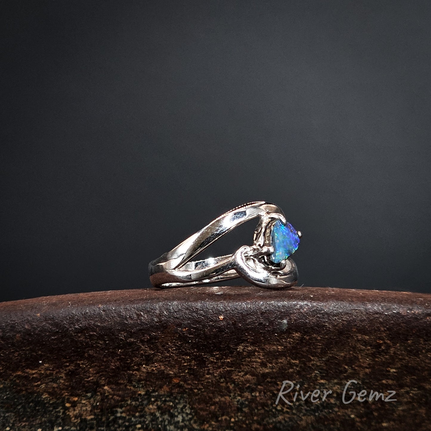 Silver ring with a blue stone on a dark background