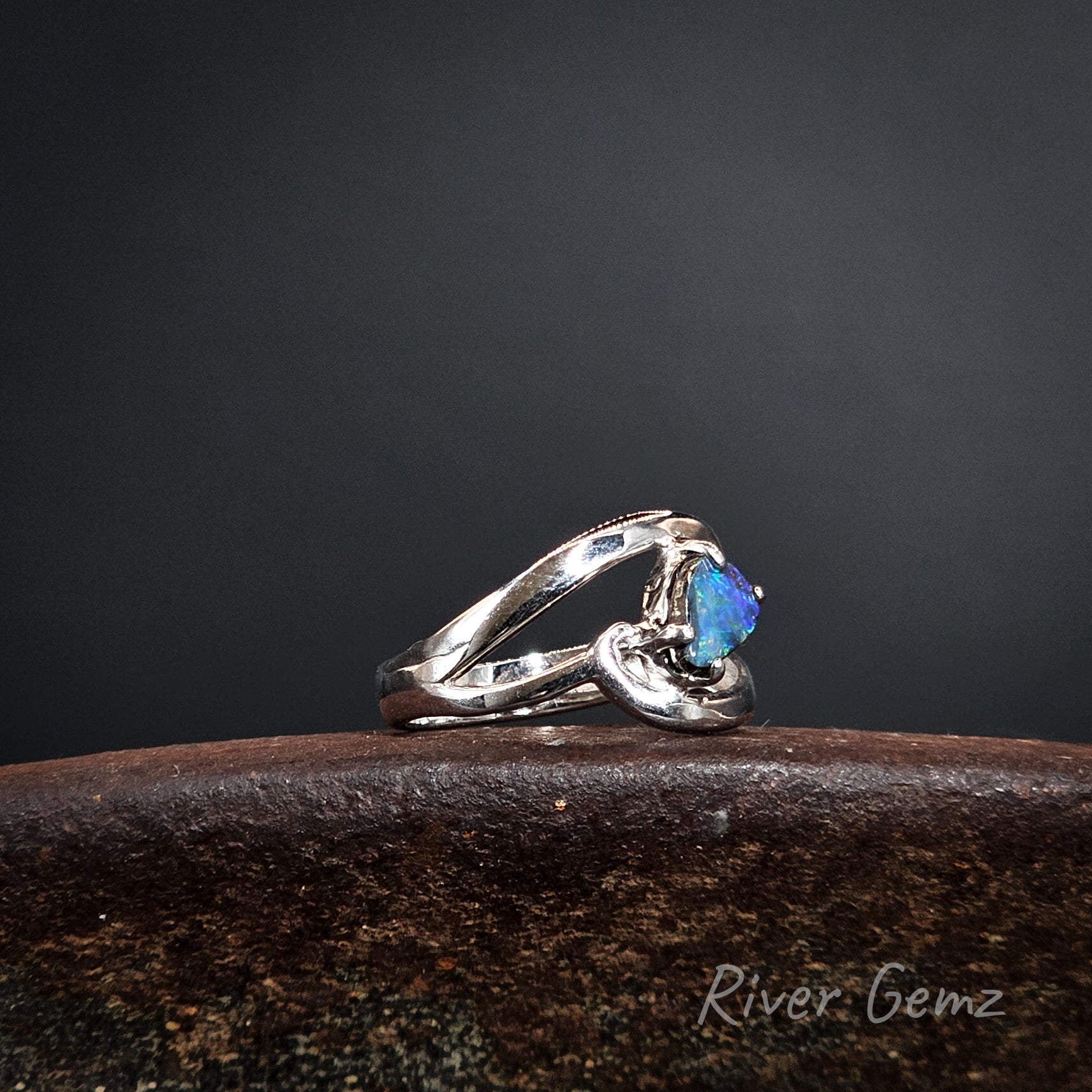 Silver ring with a blue stone on a dark background