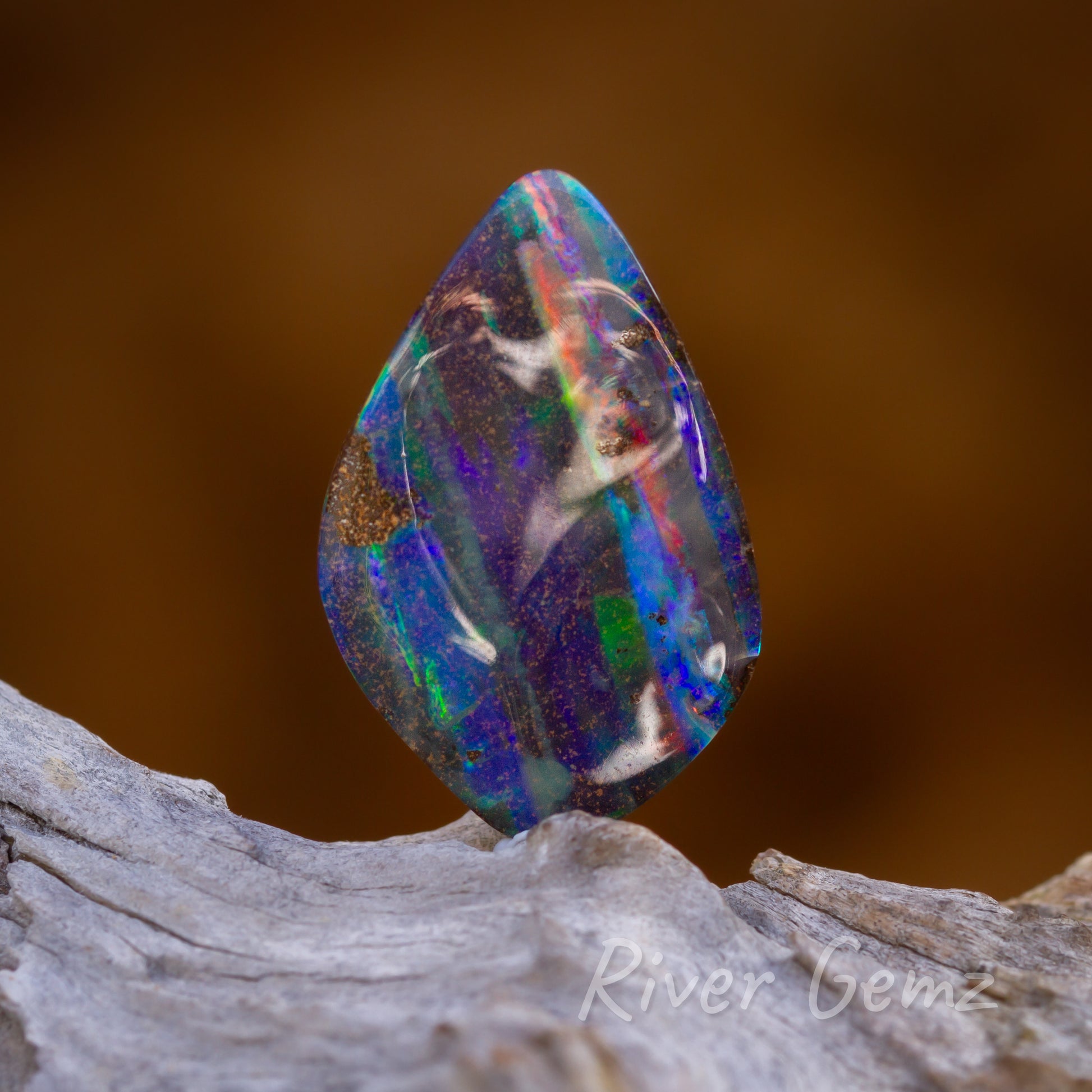 High degree of polish achieve in the undulating surface of vibrantly colourwd solid opal.