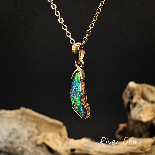 Pipe opal partial besel set in yellow gold necklace on a dark background with 'River Gemz' branding.