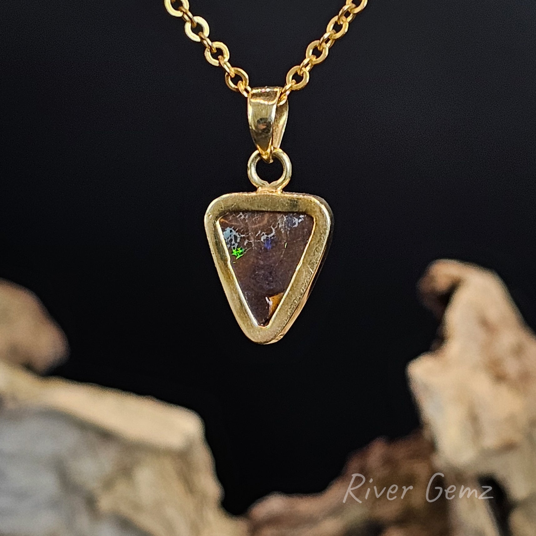 Rear view of gold necklace shows the ironstone matrix of the boulder opal within it.