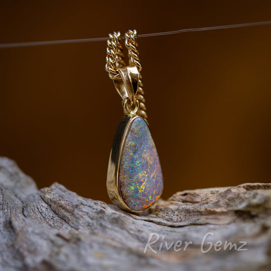 This somewhat side view of the pendant shows the thickness of the opal secured with bezel setting. Tapered bail uniquely has a vertical seam.