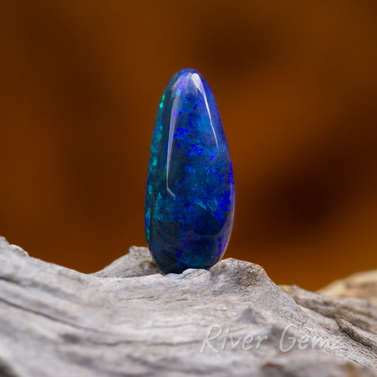 Three similar images of the vivid blue dark opal. Opal is upright base on light grey grained wood piece.