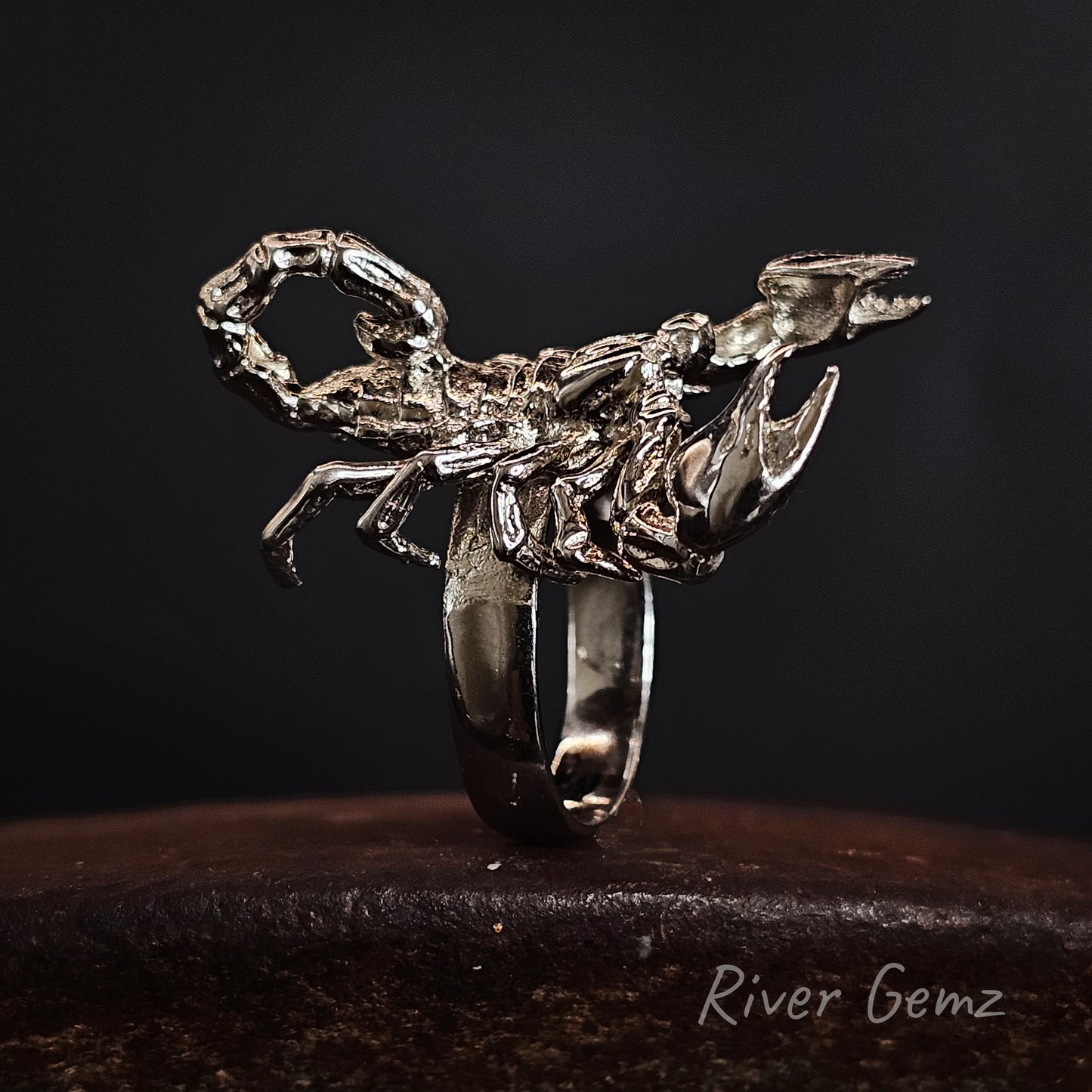 Silver scorpion-shaped ring on a dark background with 'River Gemz' branding.