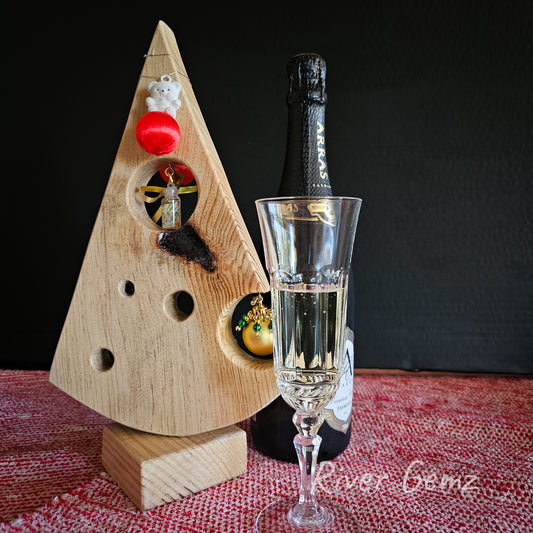 White wood shaped as Swiss cheese Christmas tree with upper cheese hole hung with opal chip vial.