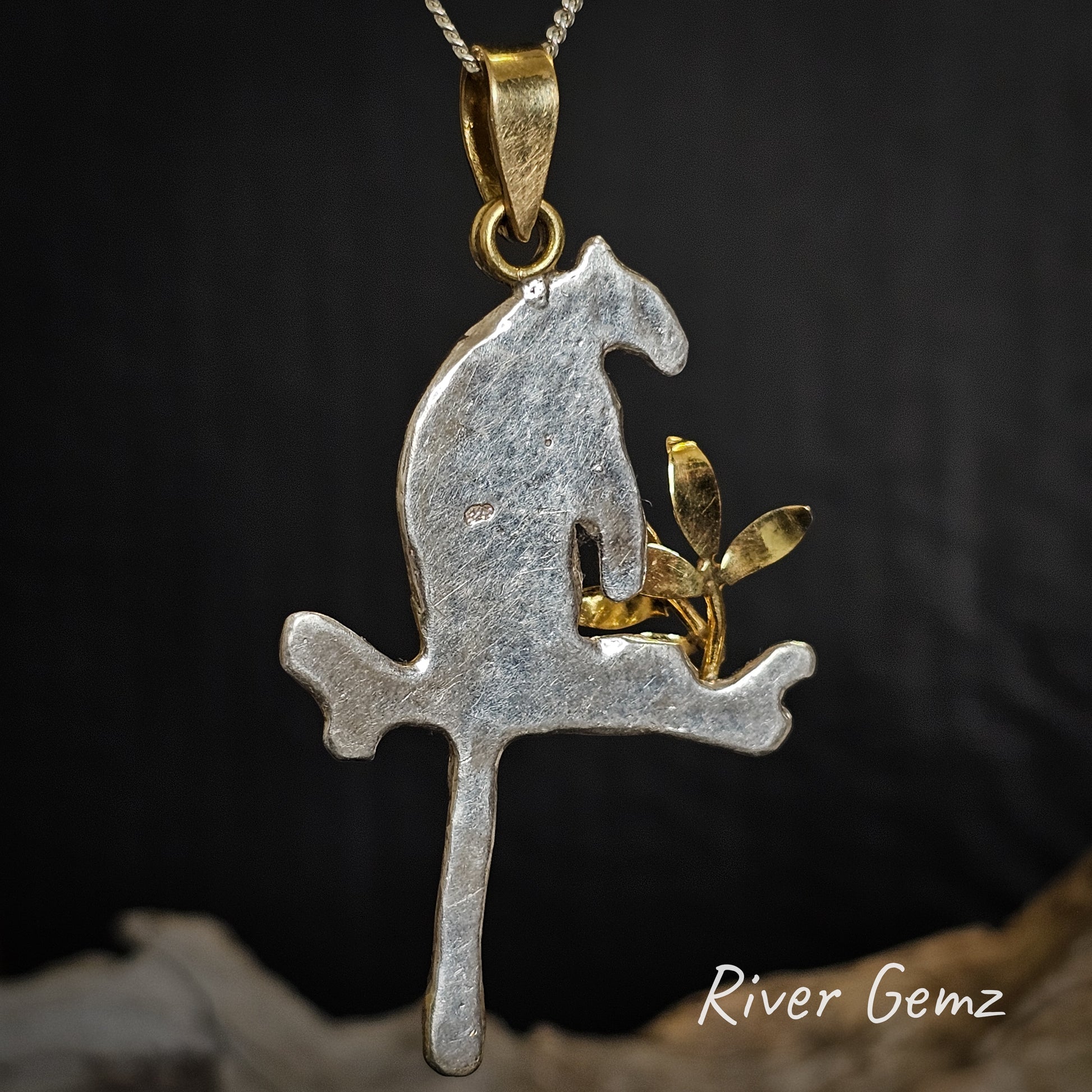 Rear view of silver and gold tree kangaroo pendant with 'River Gemz' branding on a dark background