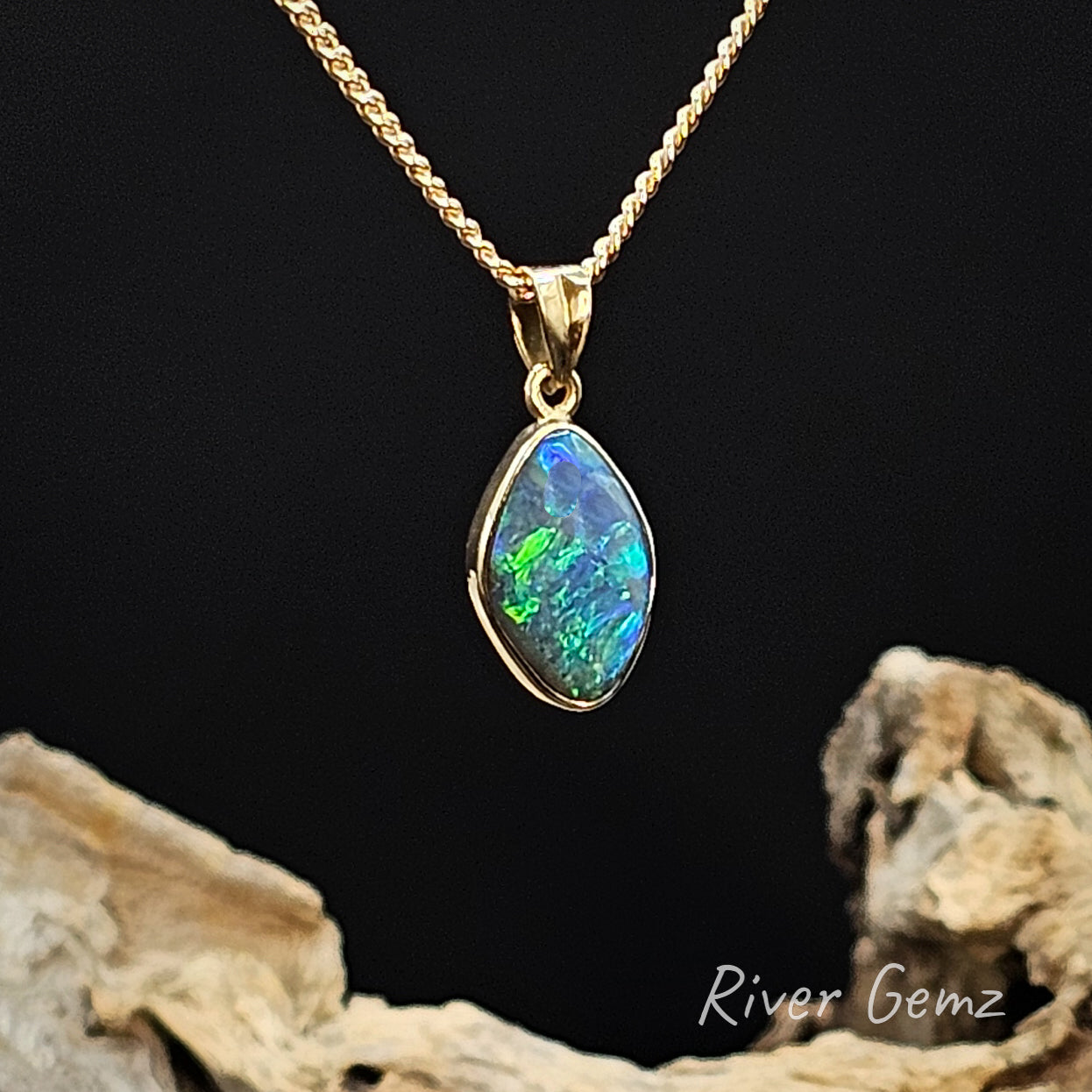 Opal pendant necklace on a gold chain with a black background and 'River Gemz' branding.