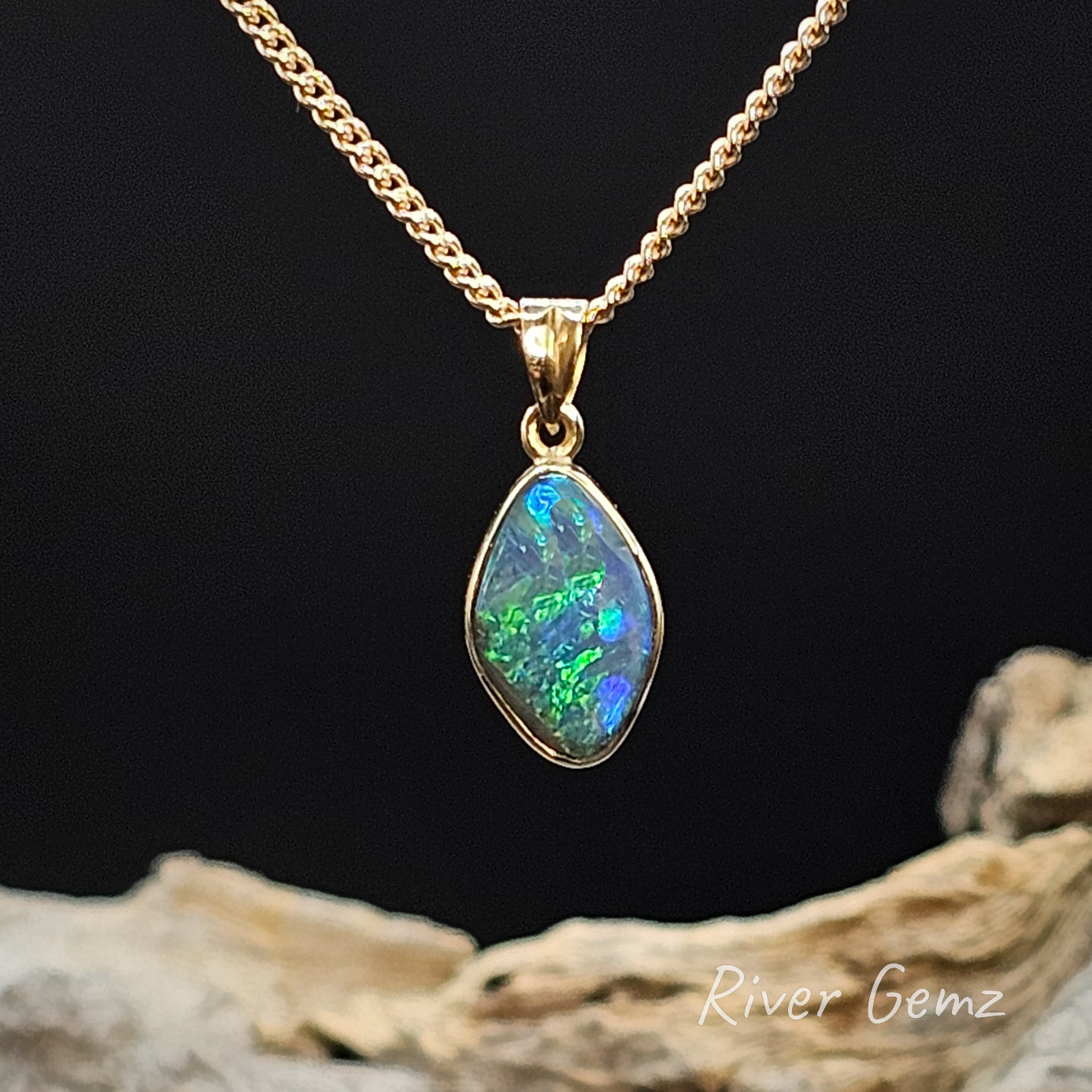 Opal pendant necklace on a gold chain with a black background and 'River Gemz' branding.