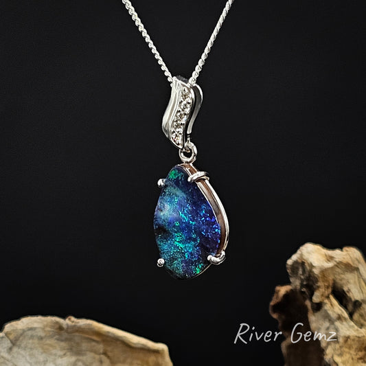 Opal pendant on a chain with a dark background and 'River Gemz' branding.