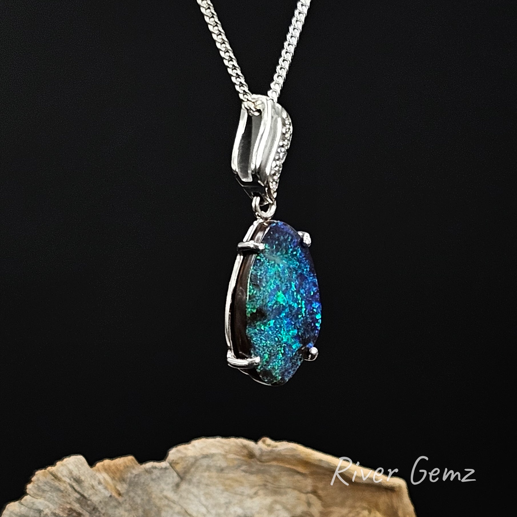 Opal and diamonds set in white gold pendant on a silver chain against a black background with 'River Gemz' branding.