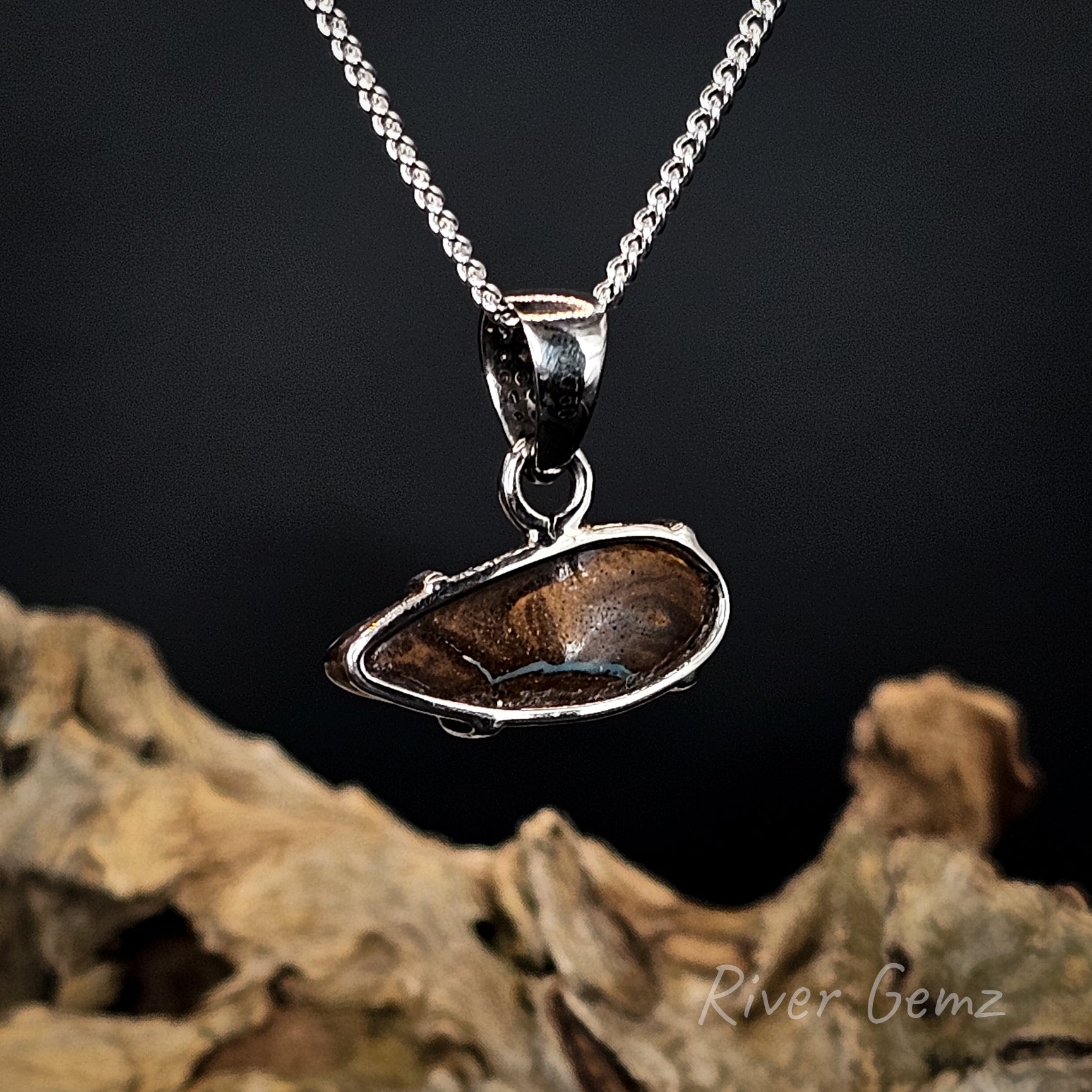 Rear view of the white gold pendant showing the ironstone matrix of the boulder opal set within it.