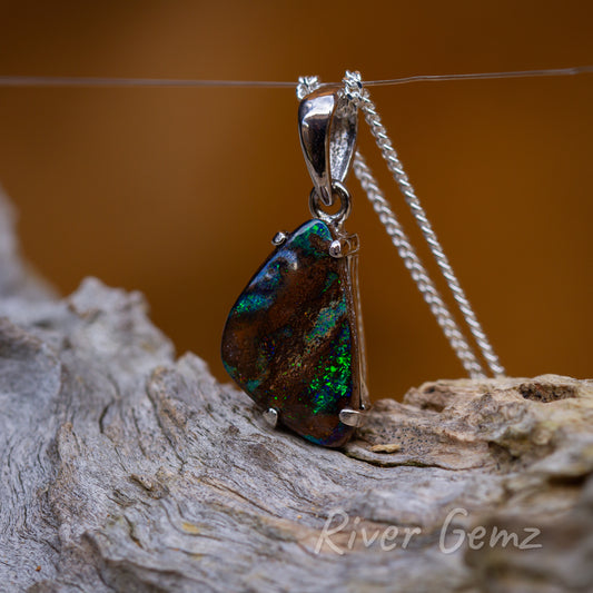 Triangular-shaped opal secured with 4 claws to the pendant. Large tapered bail included.