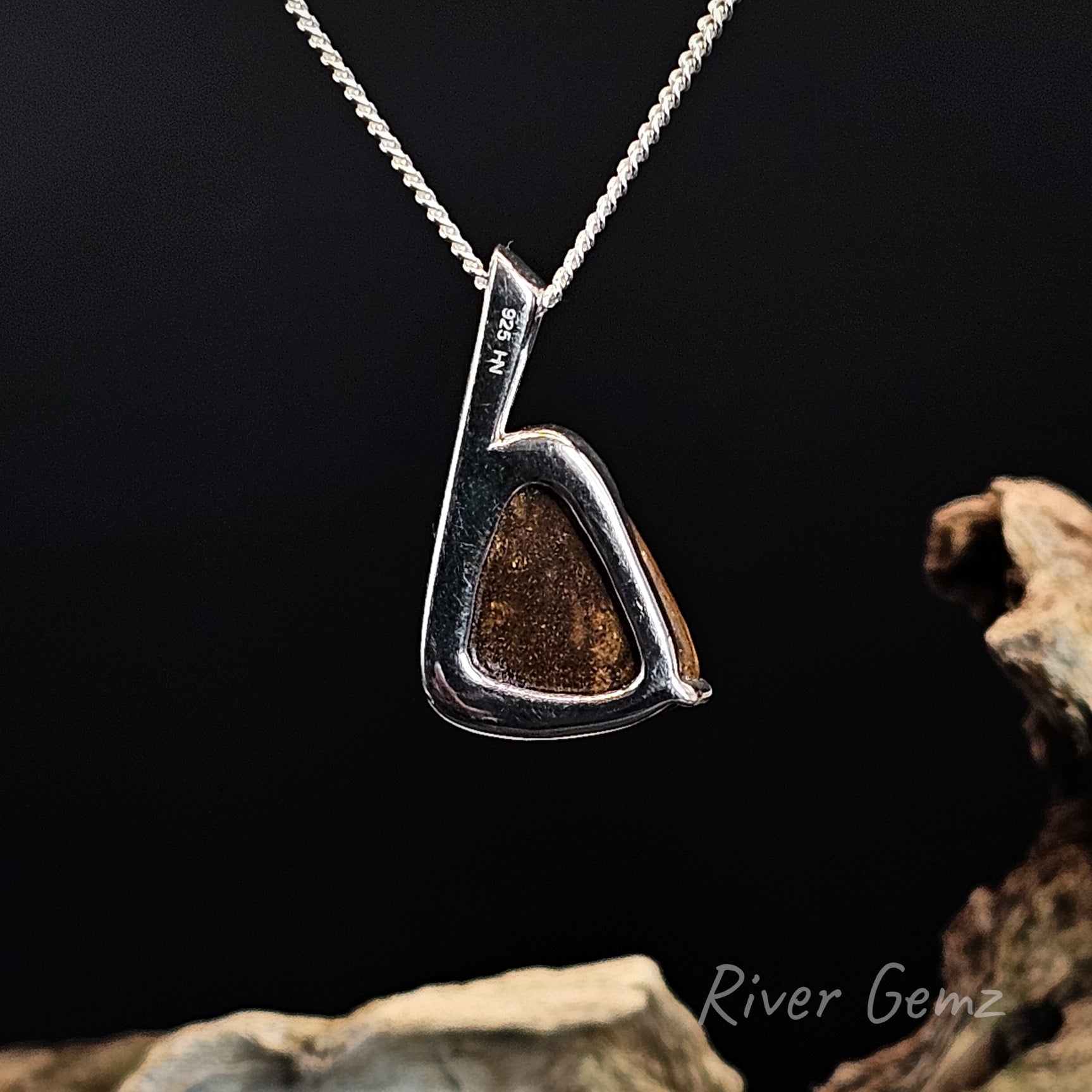 Back of pendant shows the 925 hallmark for sterling silver and the brown base of the boulder opal.