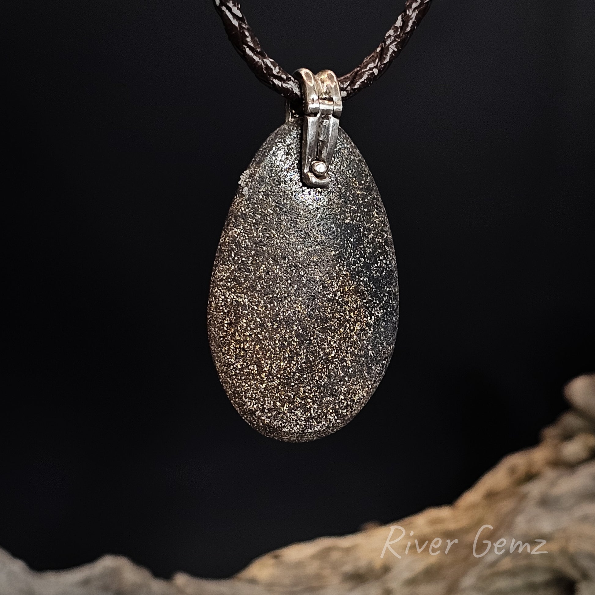 Rear view of silver pendant shows the ironstone matrix of the boulder opal.