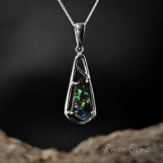 Opal pendant on a chain with a dark background, featuring the brand 'River Gemz'.
