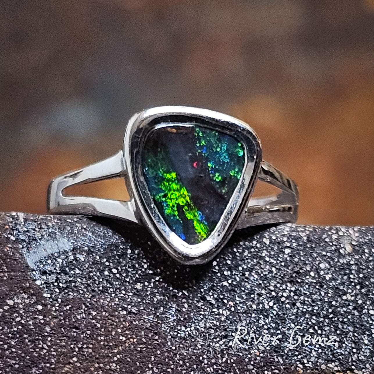 Front view of the dark opal with vivid greens and blues with a hint of red in the stripe pattern.