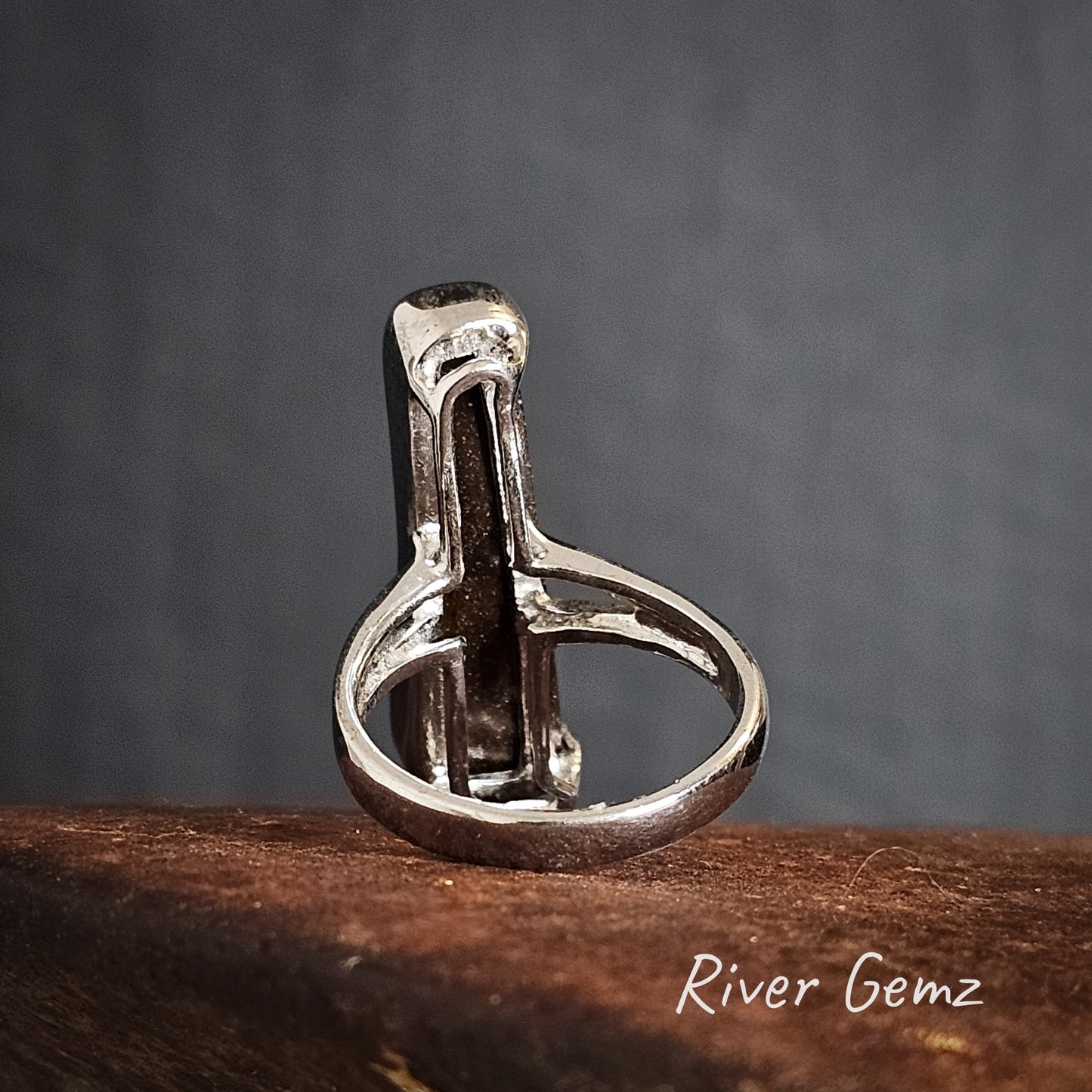 Rear view of the silver ring with a to show the dark ironstone matrix of the boulder opal set in it.