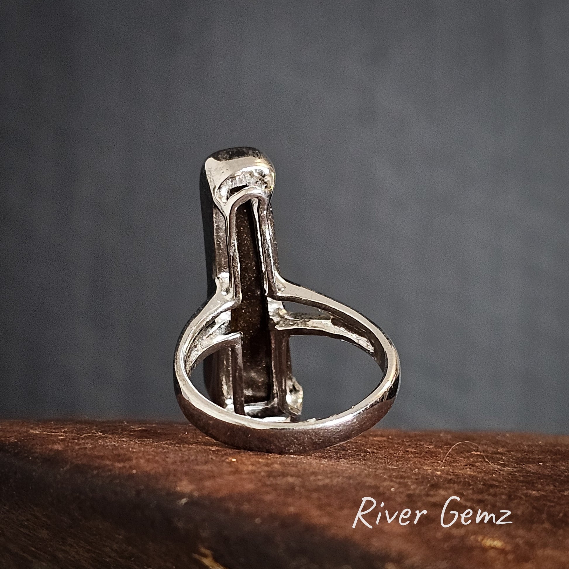 Rear view of the silver ring with a to show the dark ironstone matrix of the boulder opal set in it.