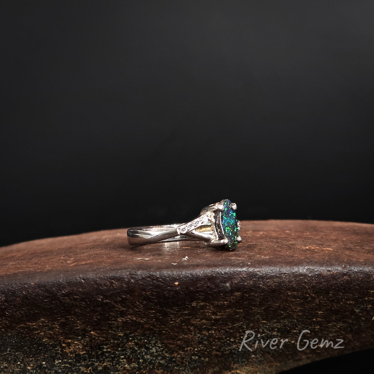 Side view of the ring shows the cross over shoulders and the thickness of the featured boulder opal.