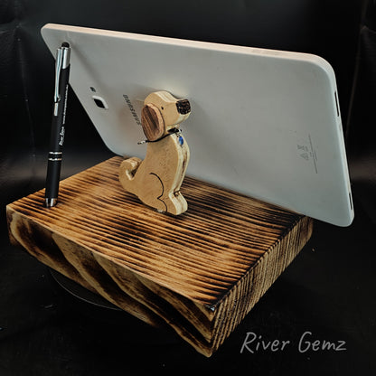 Tablet is leaning against a sitting dog on a torched wooden base.