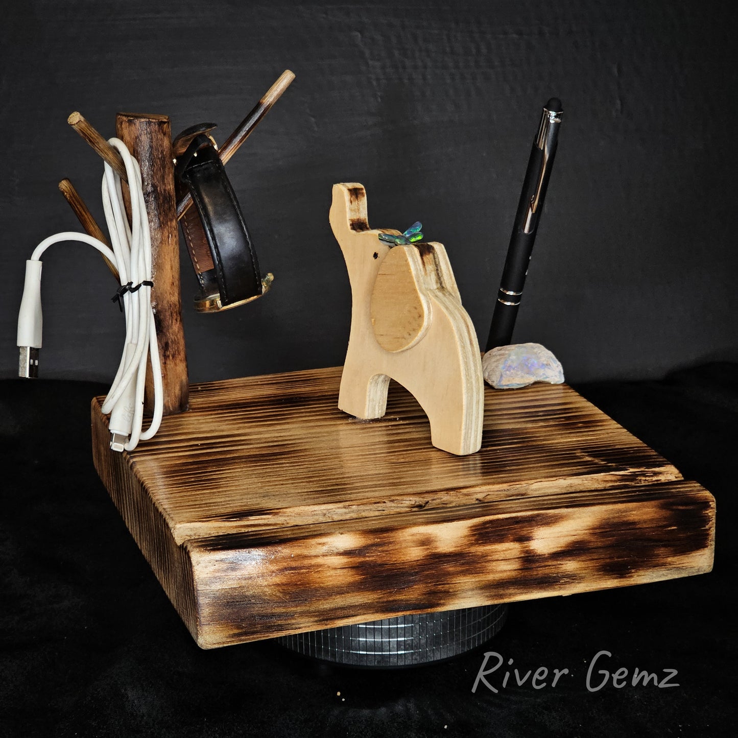 Wooden desk organizer with various items on a black background, featuring the brand 'River Gemz'.