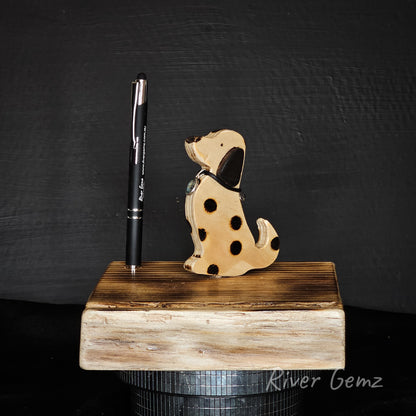 Wooden dog-shaped phone and tablet holder with a pen on a black background, branded 'River Gemz'.