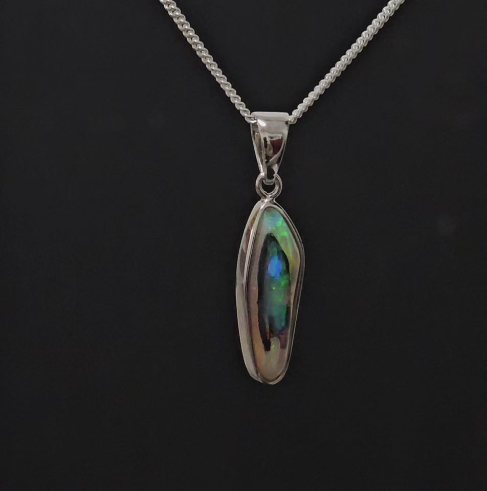 Unusual opal set in silver necklace shown spinning 180 degrees.