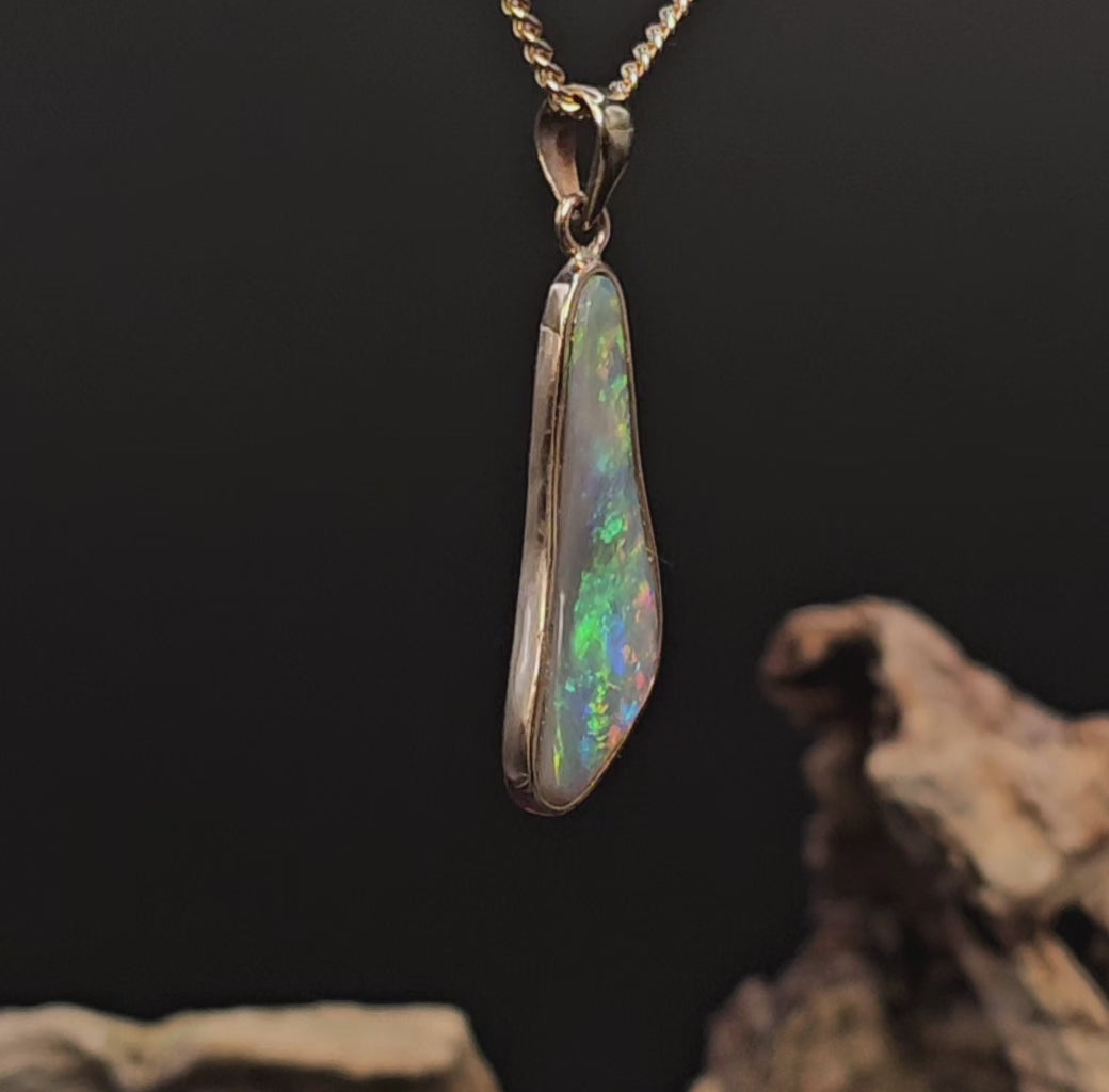Video showing the gold pendant with multi-coloured opal rotate to show all sides of the necklace.