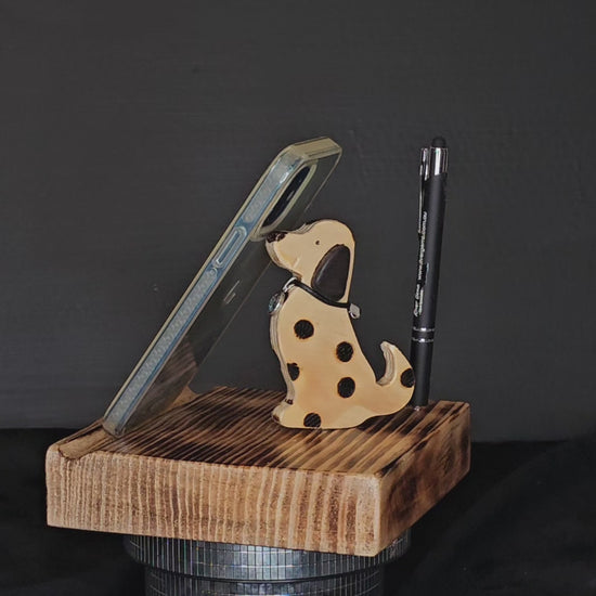 Wooden tablet stand with spotted dog and pen shown to rotate 180 degrees.
