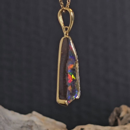 Video showing the diamond and boulder opal gold pendant rotate 180 degrees.