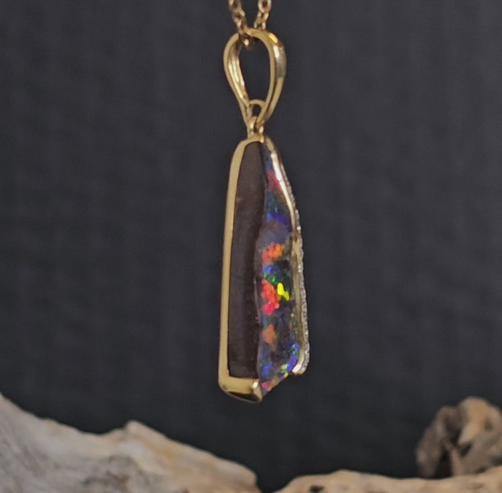 Video showing the diamond and boulder opal gold pendant rotate 180 degrees.