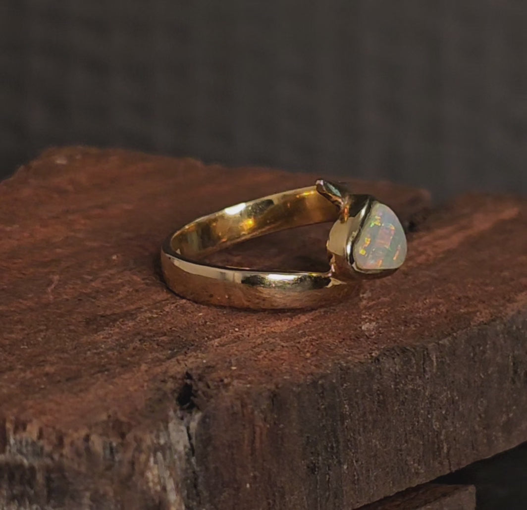Video showing the gold ring besel set with a white opal rotate 180 degrees.