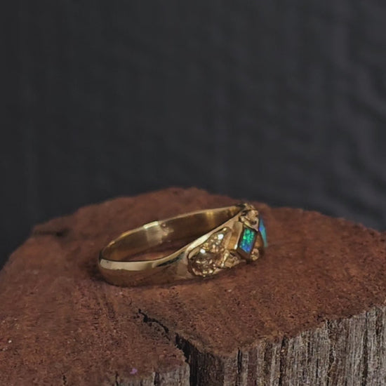 Video showing gold nugget and dark blue and green opal ring rotate 200 degrees.