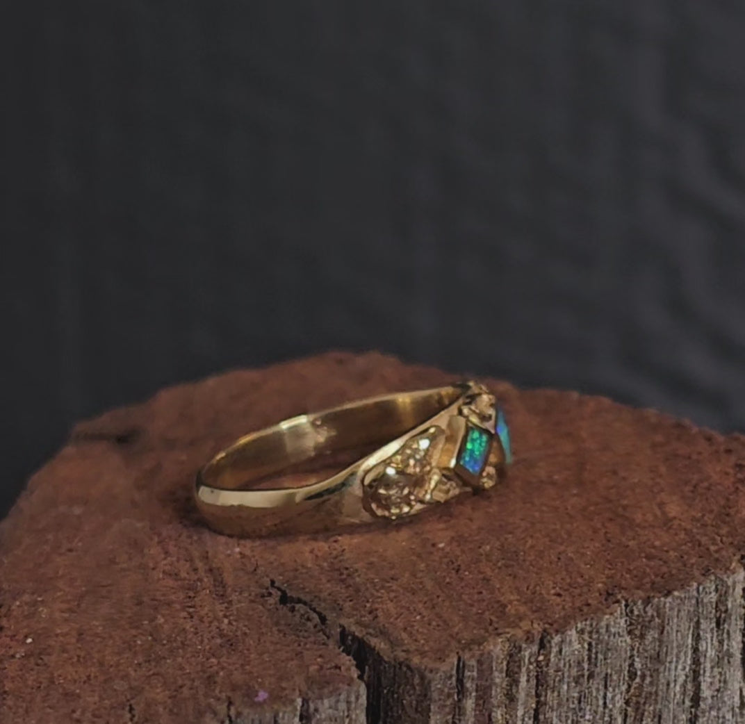 Video showing gold nugget and dark blue and green opal ring rotate 200 degrees.
