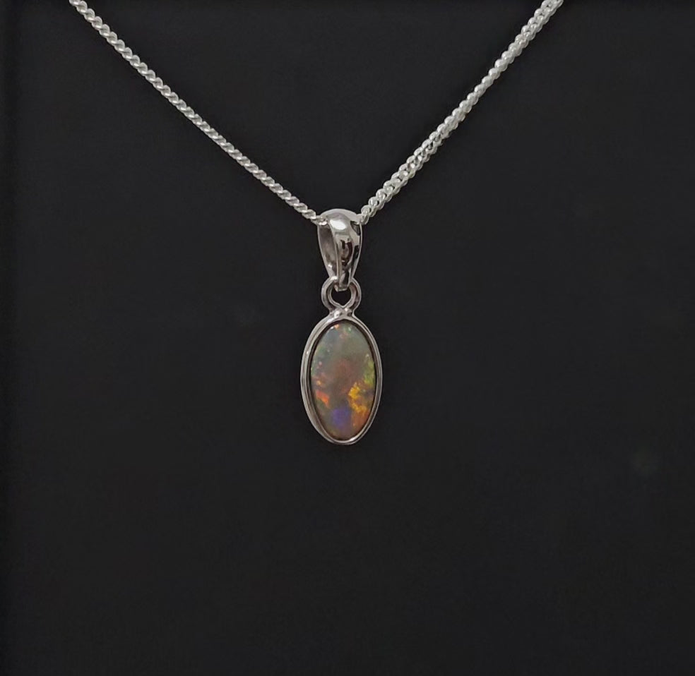 Classically besel set dark opal set in silver shown spinning for 300 degree visual of the necklace.