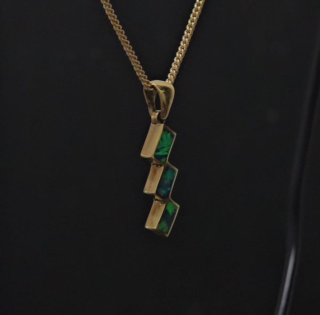 3 cubes with multi-coloured opals interconnected in yellow gol necklace.