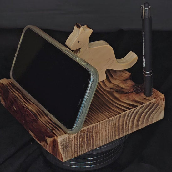 Video showing the wooden mobile phone stand rotate with a phone standing in landscape position against the kangaroo.