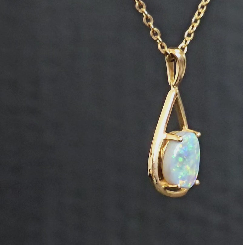 Dark multi-coloured opal claw set in yellow gold modern style pendant.