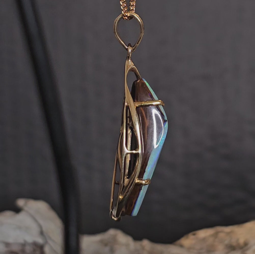 Video showing the boulder opal in gold pendant rotate 180 degrees.