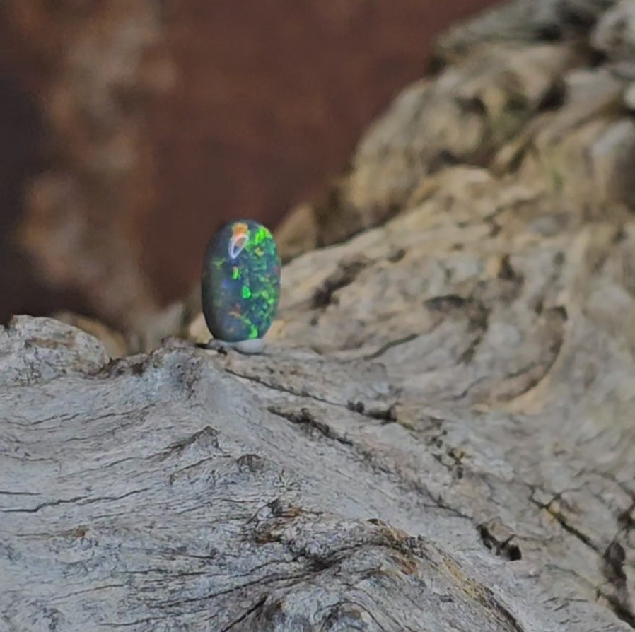 Video showing small unset black opal rotate to reveal 180 degree view.