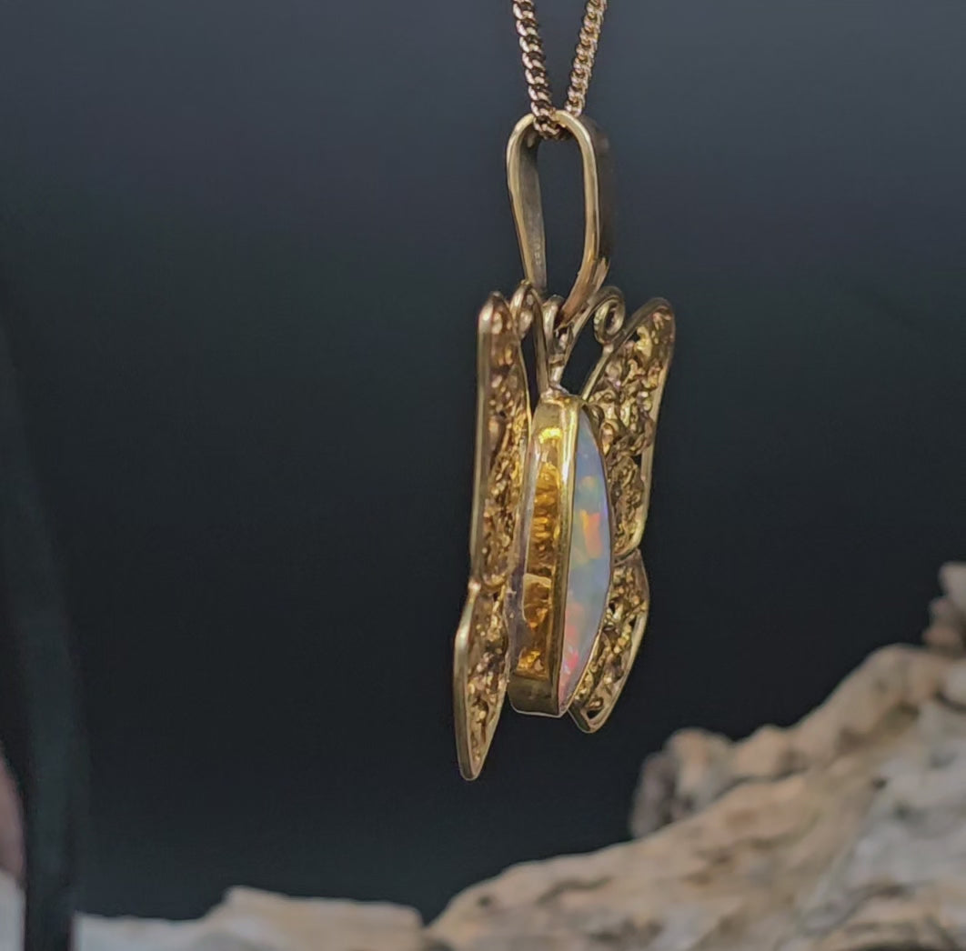 Video showing the gold necklace in the form of a butterfly with gold nugget wings and boulder opal body rotate 180 degrees.