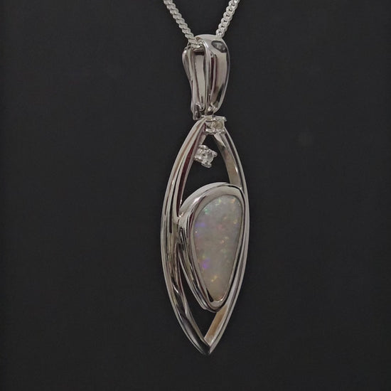 Large silver pendant adorned with light opal spinning to give 360 degree view.